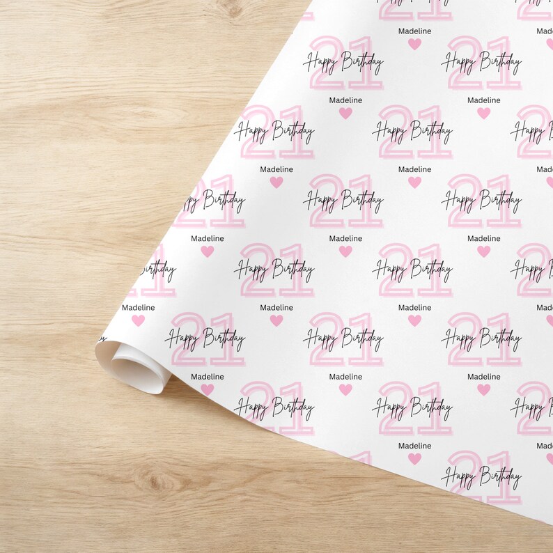 May include: Pink and white wrapping paper with a repeating pattern of the number 21 in pink with the text "Happy Birthday" and the name "Madeline".