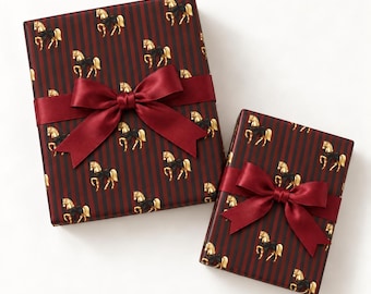 Peut inclure: Deux boîtes cadeaux rectangulaires enveloppées dans du papier rayé rouge foncé et noir avec un motif répétitif de chevaux dorés avec des nœuds noirs. Chaque boîte est nouée avec un large ruban de satin rouge profond fini par un grand nœud.