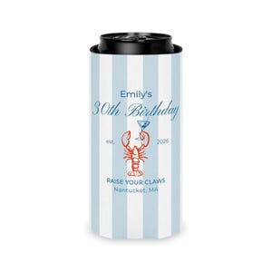 May include: A blue and white striped can cooler. The text "Emily's 30th Birthday" is in blue script. A red lobster graphic is centered below the text, with the words "Raise Your Claws" and "Nantucket, MA" below it. The year 2026 is also printed on the cooler.