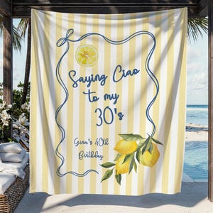 May include: A yellow and white striped beach towel with the text "Saying Ciao to my 30's" and "Gina's 40th Birthday". The towel features a lemon slice and a lemon branch with green leaves.