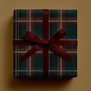 May include: A wrapped gift box with a dark green plaid pattern and a burgundy ribbon tied in a bow. The plaid design features lines of red and tan, creating a classic and festive look. The gift is presented on a solid tan background.