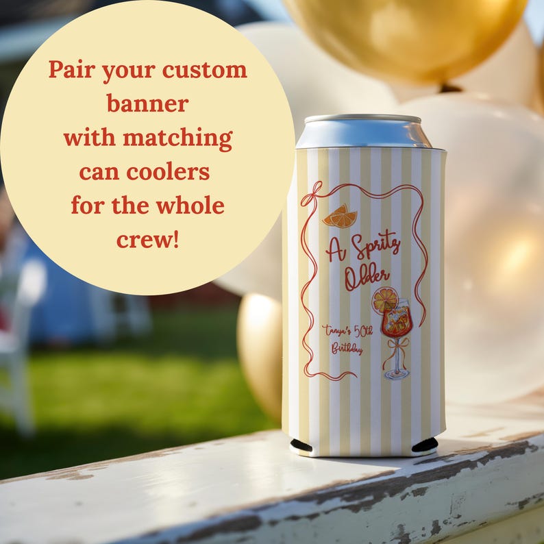 May include: A white and yellow striped can cooler with the text "A Spritz Older" and "Tanya's 50th Birthday" in a decorative frame. The cooler has a graphic of a cocktail and orange slices.