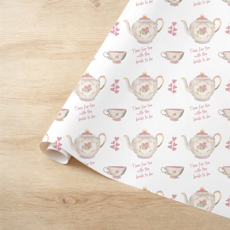 May include: White wrapping paper with a repeating pattern of pink teapots, teacups, and hearts. The text "Time for tea with the bride to be" is repeated throughout the pattern.