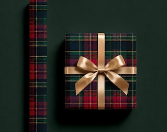 May include: A square gift box wrapped in dark green, red, and yellow plaid paper, tied with a smooth gold satin ribbon bow, positioned next to a vertical roll of the same matching plaid wrapping paper against a solid dark green background.