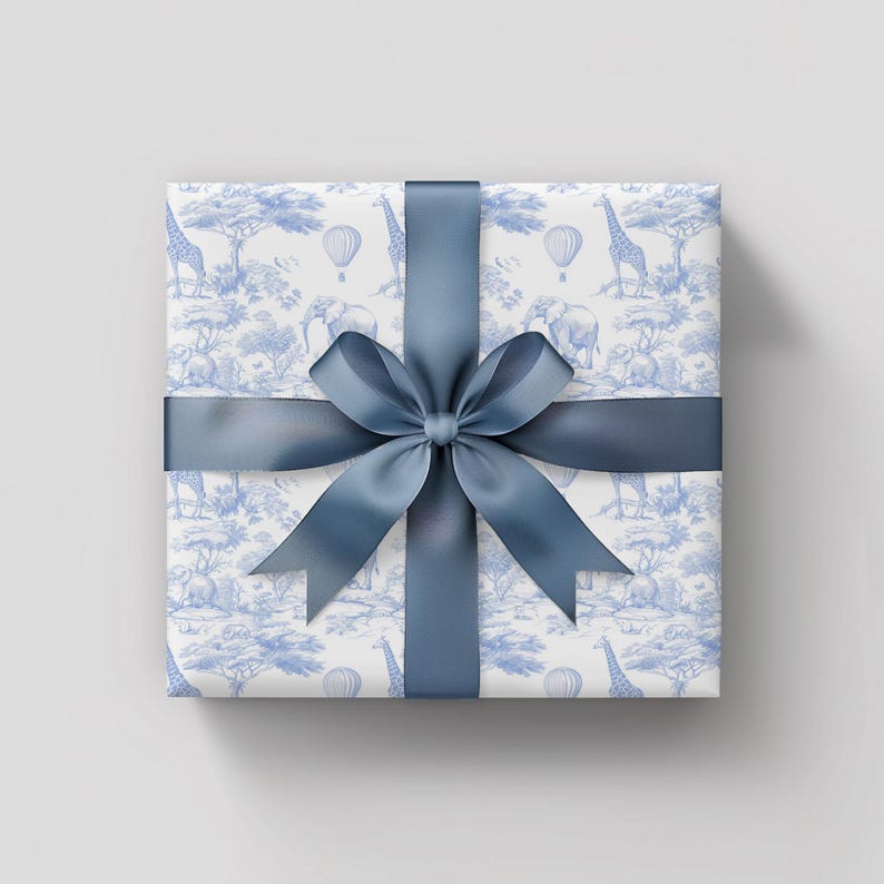May include: A white gift box with a blue ribbon and a blue and white pattern of giraffes, elephants, and hot air balloons.