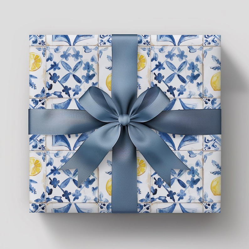 May include: A gift box wrapped in blue and white patterned paper with a blue bow. The paper features a repeating pattern of blue and white tiles with lemons.
