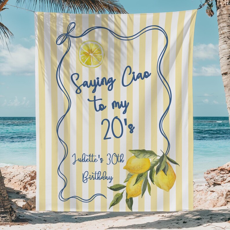 May include: A beach towel with vertical yellow and white stripes. The towel has a blue border with the text "Saying Ciao to my 20's" and "Juliette's 30th Birthday". A lemon slice and lemon branch are also featured.