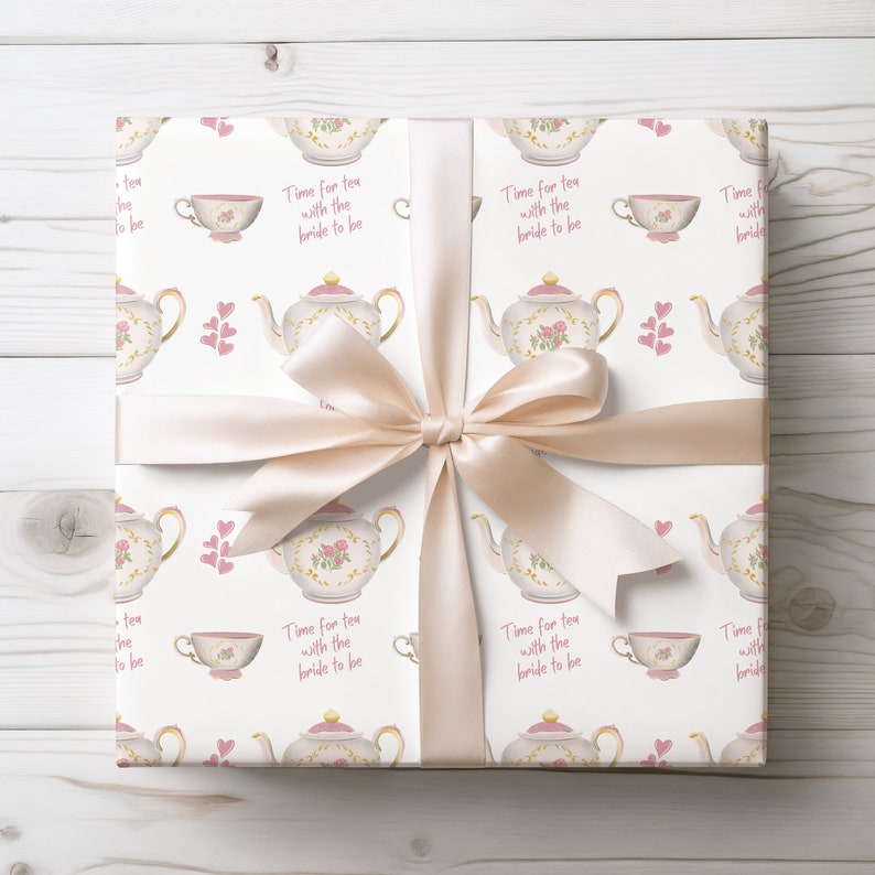 May include: A white gift box with a pink ribbon and a teacup and teapot pattern. The box has the text "Time for tea with the bride to be" repeated on each side.