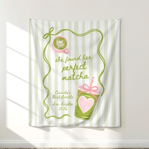 Puede incluir: Un tapiz de pared a rayas blancas y verdes con el texto "she found her perfect matcha". El diseño incluye un latte de matcha rosa y una bebida de matcha verde con un corazón rosa. También se incluye el texto "Cassidy's Bachelorette Los Angeles 2026".