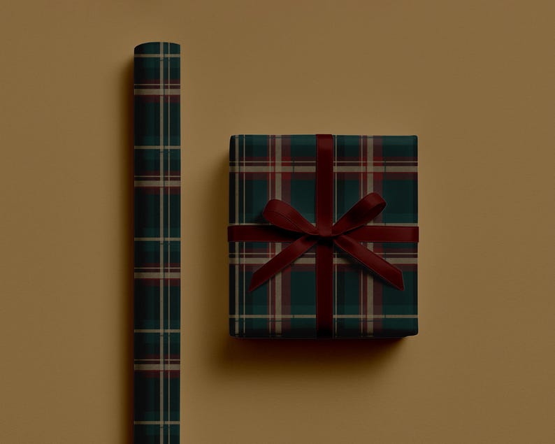 May include: A roll of plaid wrapping paper and a wrapped gift box. The wrapping paper and gift box feature a dark green, burgundy, and beige plaid pattern. The gift box is tied with a burgundy ribbon.