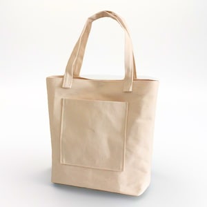 K&ouml;nnte beinhalten: Eine schlichte, cremefarbene Canvas-Tragetasche mit einer gro&szlig;en Tasche auf der Vorderseite. Die Tasche hat zwei Henkel.