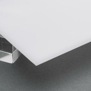 May include: A white cutting board made of a durable material. The board is smooth and has a slightly textured surface.