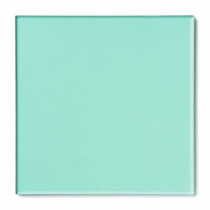 May include: A square piece of light blue frosted glass.