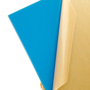 May include: A sheet of blue acrylic with a protective paper backing. The paper is partially peeled back to reveal the blue acrylic.