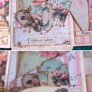 Pu&ograve; includere: Un diario in stile vintage a tema floreale. Il diario presenta vari tag e inserti adornati con rose e illustrazioni botaniche. Il testo "VINTAGE GARDEN" &egrave; visibile su un'etichetta. La tavolozza dei colori comprende rosa, verde e crema.