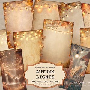 May include: A collection of journaling cards with an autumn theme. The cards feature a warm color palette of browns, oranges, and yellows, with string lights and fall foliage. The text "AUTUMN LIGHTS JOURNALING CARDS" is displayed on a decorative label.
