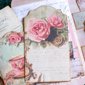 Pu&ograve; includere: Una collezione di efemeridi di carta in stile vintage con un tema rosa e floreale. Il punto focale &egrave; un'etichetta con rose rosa, scritte e un orologio decorativo. Altri elementi includono un'illustrazione di tazza da t&egrave; e il testo "CitrusJournalStudio on Etsy."