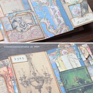 May include: A vintage-style scrapbook with decorative paper, embellishments, and handwritten notes. The scrapbook is open to reveal a page with a drawing of a chandelier and the number 2345.