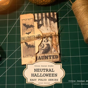 May include: A vintage-style Halloween folio, featuring bat silhouettes and the word "Halloween." The design includes a raven illustration and is tied with twine. The text reads "Neutral Halloween Easy Folio Series."
