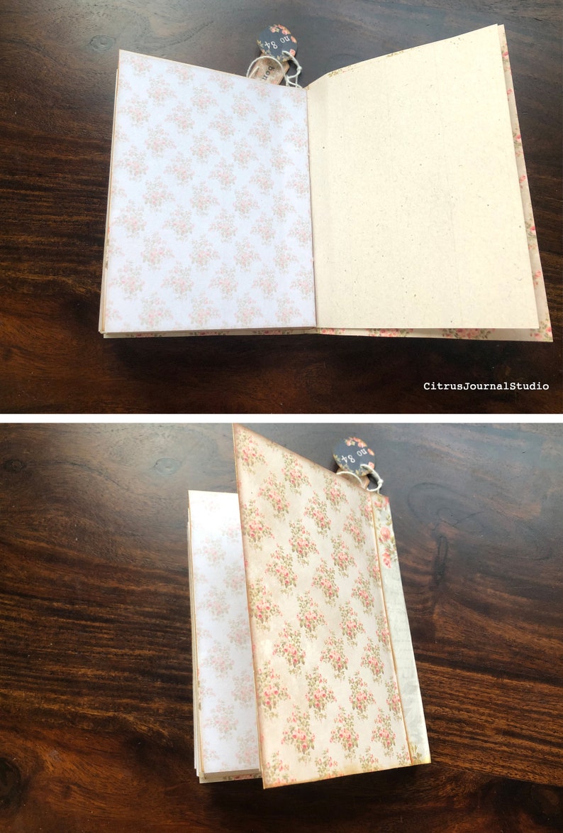 May include: A closed journal with a floral patterned cover. The journal has a brown paper cover with a floral pattern in pink and green. The journal is closed and has a tag attached to it that says "80 pages".
