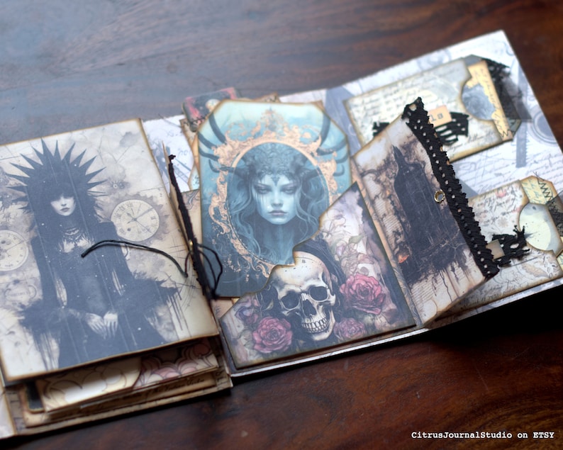 May include: A handmade journal with a dark and gothic theme. The cover features a black and white illustration of a woman with a crown of thorns. The inside pages are decorated with various images, including a skull, roses, and a woman with long hair. The journal is bound with black thread and has a black lace trim.