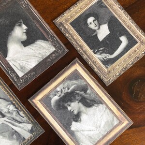 Puede incluir: Cuatro fotograf&iacute;as vintage enmarcadas de mujeres en blanco y negro. Los marcos son ornamentados y tienen un acabado dorado. Las fotos est&aacute;n impresas en papel hecho a mano.