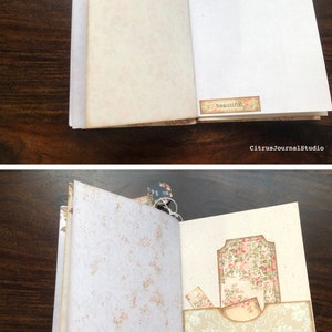 May include: Open vintage journal with floral patterned pages. The left page has a floral border and the right page has a small tag with the word "beautiful" on it. The next page has a floral patterned pocket with a tag that says "nouvelle edition".