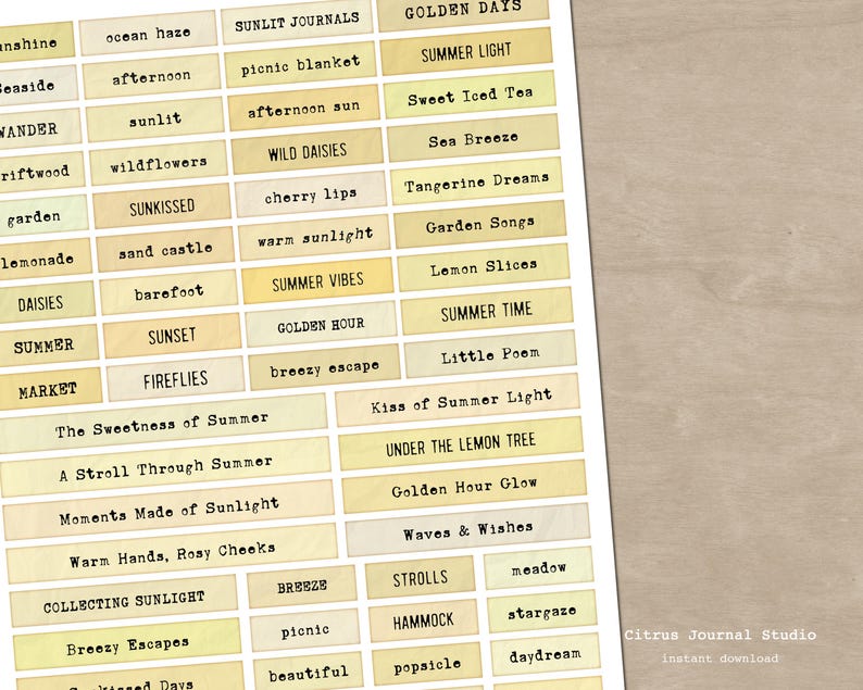 May include: A sheet of paper with various rectangular labels featuring summer-themed words in a vintage typewriter font. The labels are in shades of yellow and beige. Text includes "Summer Vibes," "Golden Hour," and "Sweet Iced Tea."