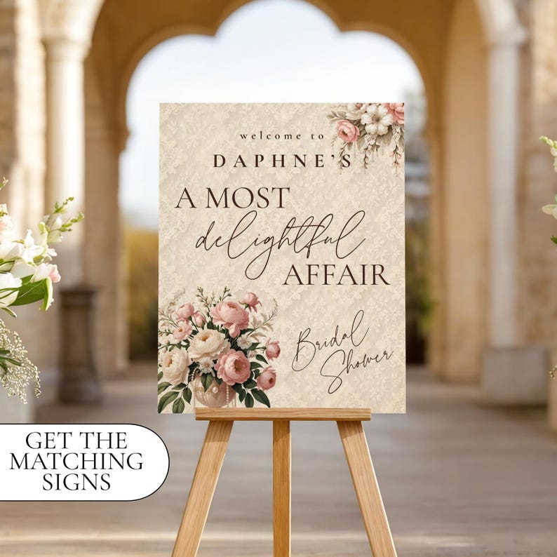 May include: A decorative sign on a wooden easel, featuring the text "Welcome to Daphne's, A Most Delightful Affair, Bridal Shower." The sign has floral accents in pink and white. The words "Get the matching signs" are in a white oval.
