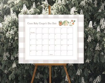 May include: A white calendar with a gray and white gingham pattern background. The calendar is titled "Guess Baby Cooper's Due Date" and shows the months of December and January. There are illustrations of a basket of fruit, a baby outfit, and a carrot.