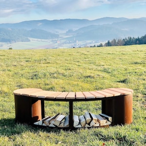 May include: A curved wooden bench with a metal frame and storage compartments for firewood. The bench is set against a backdrop of a grassy field and rolling hills.