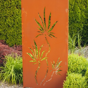 May include: A rust-colored metal garden screen with a cutout design of three palm trees. The screen is standing in front of a green hedge.