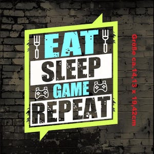 Könnte beinhalten: Eine grüne und gelbe Sprechblase mit dem Text "EAT SLEEP GAME REPEAT" in Weiß und Blau. Der Text ist in einer Graffiti-Schriftart. Die Sprechblase befindet sich auf einem schwarzen Ziegelmauerhintergrund. Die Größe der Grafik beträgt ca. 35,9 cm x 49,3 cm.