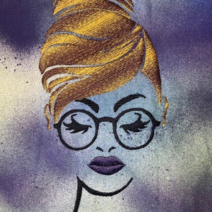May include: Embroidered illustration of a woman with a bun hairstyle, wearing round glasses and purple lipstick. The background is a blue and purple watercolour wash.