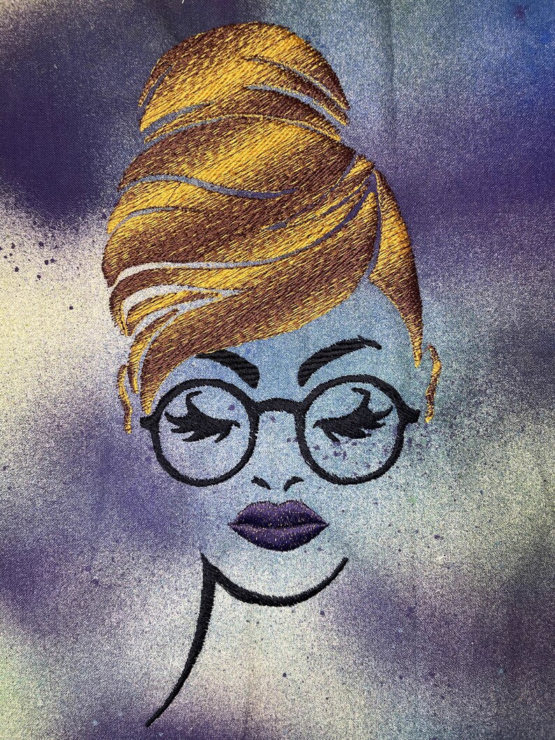 May include: Embroidered illustration of a woman with a bun hairstyle, wearing round glasses and purple lipstick. The background is a blue and purple watercolour wash.
