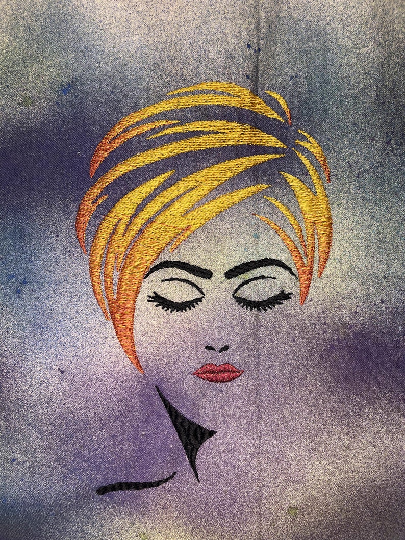 May include: Embroidered image of a woman with closed eyes and a short, blonde hairstyle. The background is a textured, purple and yellow gradient.