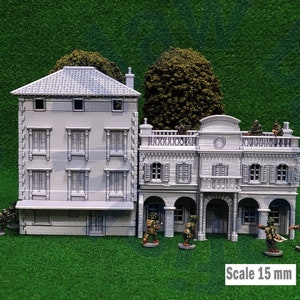 Puede incluir: Edificios grises en miniatura con fachadas, ventanas y balcones detallados, sobre una superficie verde. Incluye peque&ntilde;as figuras, &aacute;rboles y el texto "Scale 15 mm". Ideal para juegos de mesa o modelismo.