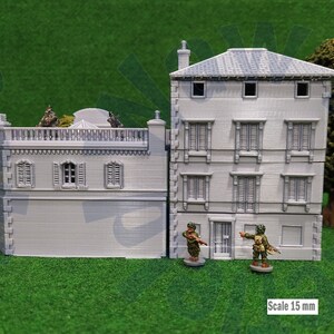 Puede incluir: Maqueta gris de un edificio de dos pisos con ventanas detalladas y tejado de tejas. Dos figuras en miniatura est&aacute;n de pie frente al edificio. La escala es de 15 mm.