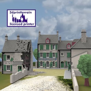 Op de afbeelding: Model van een Europese stad met gebouwen, bomen en een weg. Eén gebouw is beschadigd en een ander heeft een bord met de tekst "Cafe de Normandie". De lucht is bewolkt en de tekst "3dprintterrain licensed printer" staat linksboven.
