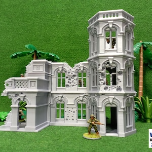May include: A gray, detailed, multi-sectioned, ruined building model with a tower, windows, and a doorway. The building has a distressed, battle-damaged look with bullet holes and missing sections. The model is set against a green background with palm trees.