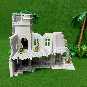 May include: A gray, ruined building with a collapsed roof and a tower. The building is made of plastic and is designed for use in tabletop wargames. There are small plastic figures of soldiers standing in the building.