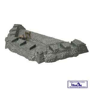 Op de afbeelding: Een grijs 3D-geprint miniatuur terreinstuk, waarschijnlijk voor een tabletop game. Het toont een loopgraafachtige structuur met gedetailleerde texturen, inclusief trappen en vestingwerken. Twee miniatuurkanonnen zijn gepositioneerd.