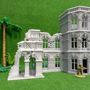 May include: A gray, detailed, multi-section model of a ruined building with a tower. The building has arched windows, a balcony, and a doorway. The model is set against a green background.