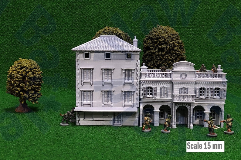 Puede incluir: Edificios grises en miniatura con fachadas, ventanas y balcones detallados, sobre una superficie verde. Incluye peque&ntilde;as figuras, &aacute;rboles y el texto "Scale 15 mm". Ideal para juegos de mesa o modelismo.