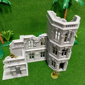 May include: A gray, detailed, multi-sectioned, ruined building model with a tower. The model is made of plastic and has a realistic, weathered look. The building is set against a green background.