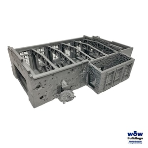 Op de afbeelding: Een grijs, 3D-geprint miniatuurmodel van een beschadigd industrieel fabrieksgebouw. De structuur heeft blootliggende stalen dakspanten, muren met baksteentextuur met meerdere kogelgaten en een grote, grillige opening in de voorste muur.