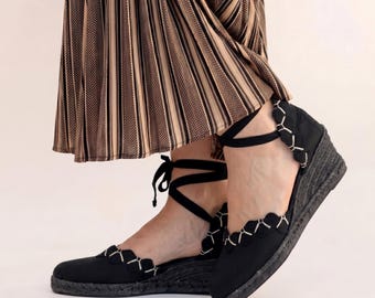 Alpargatas de cuña de yute negro, con tiras de tobillo con cordones y detalle bordado.