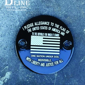 Op de afbeelding: Een ronde zwarte tankdop met een witte inscriptie die luidt: "Ik zweer trouw aan de vlag van de Verenigde Staten van Amerika en aan de republiek waarvoor zij staat, één natie onder God, ondeelbaar, met vrijheid en rechtvaardigheid voor allen". De inscriptie bevat ook een witte afbeelding van de Amerikaanse vlag.