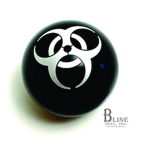May include: Black round knob with a white biohazard symbol engraved on the surface.