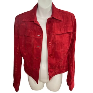 May include: A red patchwork jacket with a collared neckline and long sleeves. The jacket has a button-up front and two front pockets. The fabric appears to be suede or a suede-like material. The jacket is cropped in length.
